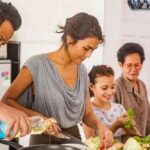 A family cooking together in the kitchen.